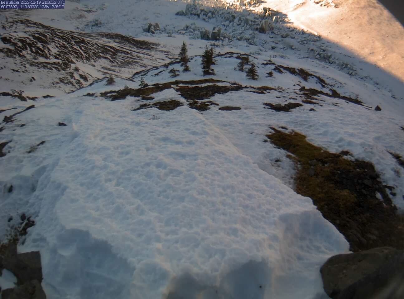 An ice covered lake dammed behind a larger glacier.